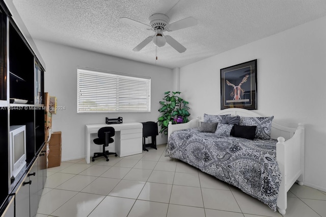 bedroom featuring ceiling fan, light tile patterned flooring, and a textured ceiling