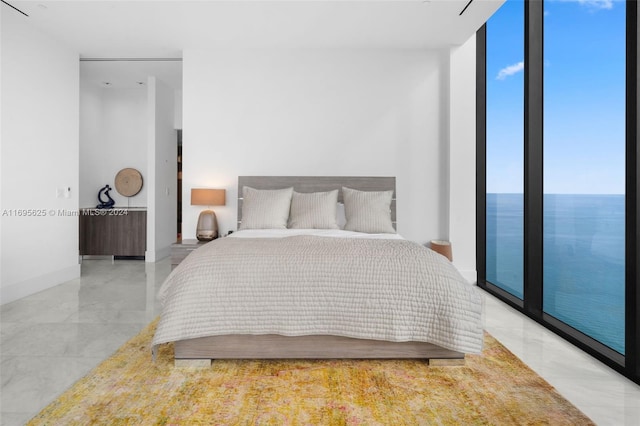 bedroom featuring access to exterior, a water view, and a wall of windows