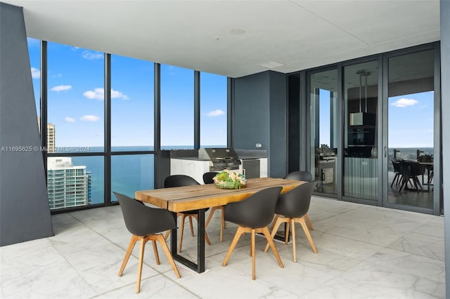 dining area with a water view and a wall of windows