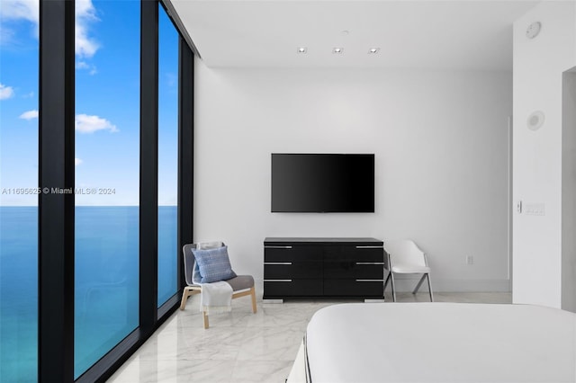 bedroom featuring a water view and expansive windows