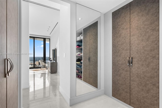 hallway featuring light tile patterned floors and expansive windows