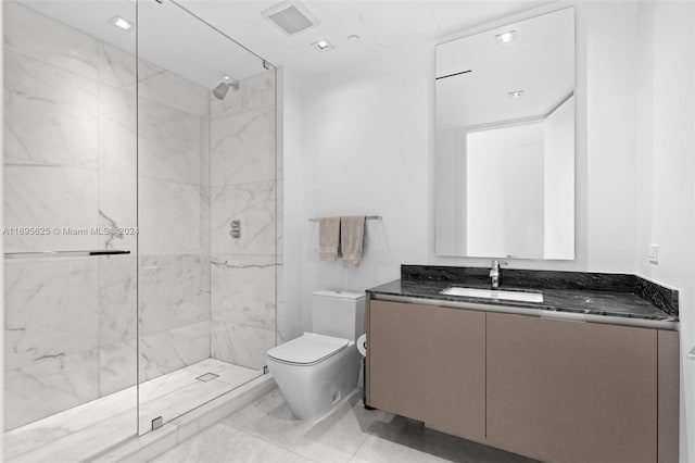 bathroom featuring vanity, toilet, and tiled shower