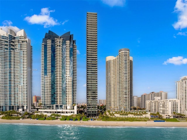 view of building exterior with a water view and a beach view