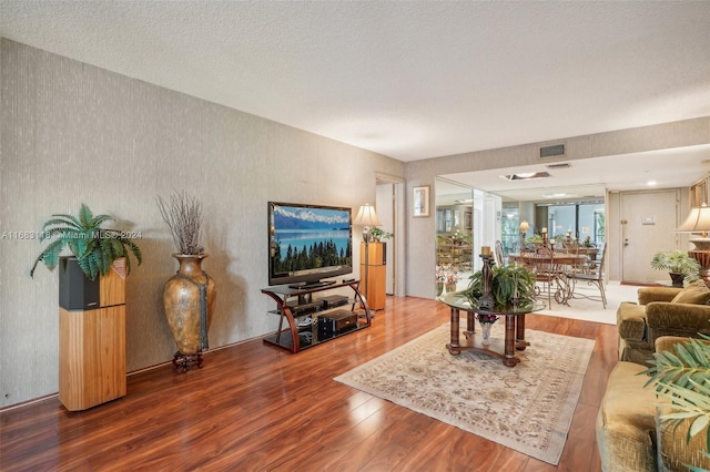 living room featuring wood-type flooring and a textured ceiling