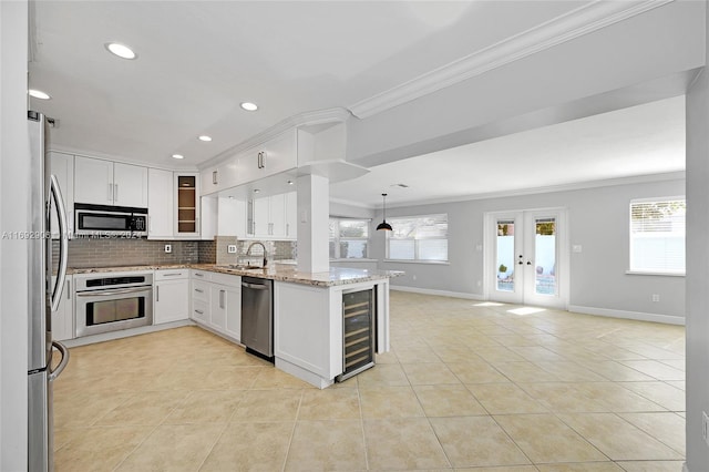 kitchen featuring a healthy amount of sunlight, white cabinetry, french doors, and stainless steel appliances