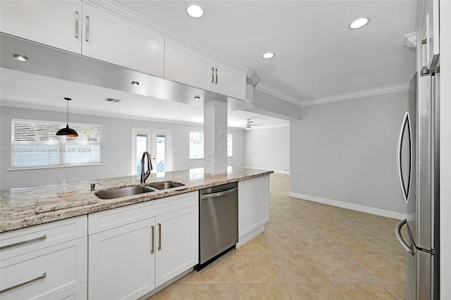 kitchen featuring white cabinets, appliances with stainless steel finishes, light stone countertops, and sink