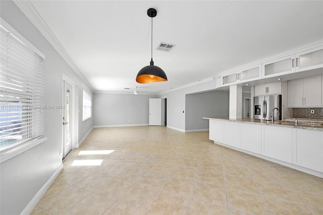 unfurnished living room featuring ceiling fan, ornamental molding, sink, and light tile patterned floors