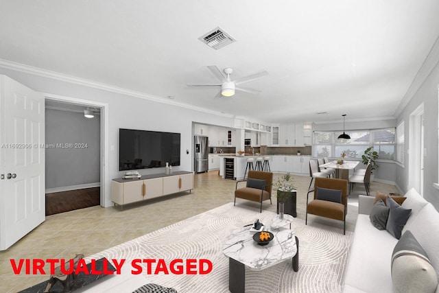 tiled living room featuring ceiling fan and crown molding