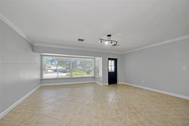 unfurnished room featuring light tile patterned floors and crown molding