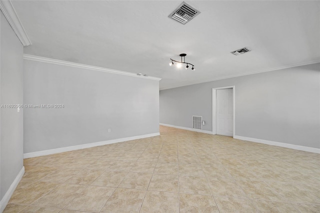 spare room featuring light tile patterned floors and crown molding