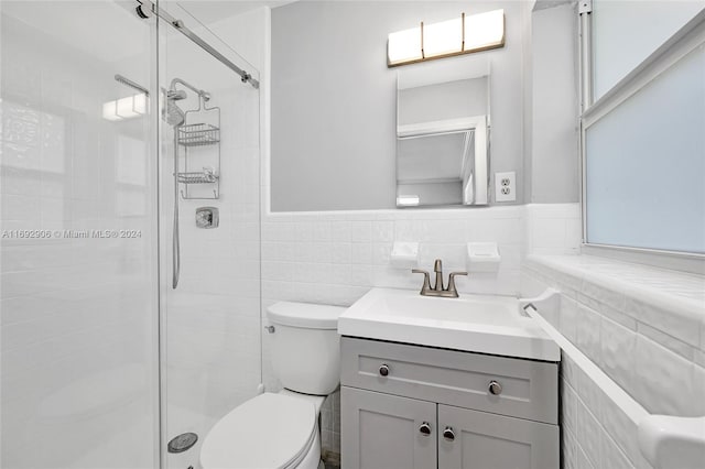 bathroom featuring an enclosed shower, vanity, toilet, and tile walls