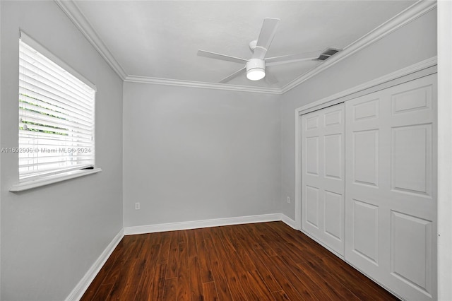 unfurnished bedroom featuring crown molding, ceiling fan, a closet, and dark wood-type flooring