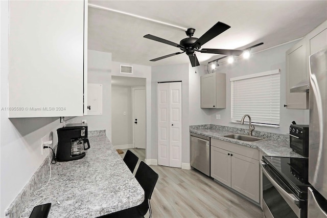 kitchen with white cabinets, sink, ceiling fan, light wood-type flooring, and stainless steel appliances