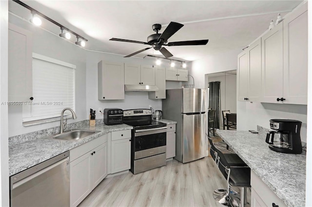 kitchen featuring white cabinets, sink, ceiling fan, light hardwood / wood-style floors, and stainless steel appliances