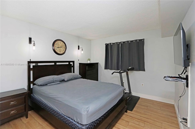 bedroom featuring a textured ceiling and light wood-type flooring