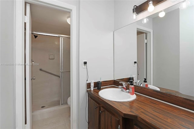 bathroom with tile patterned flooring, vanity, toilet, and walk in shower