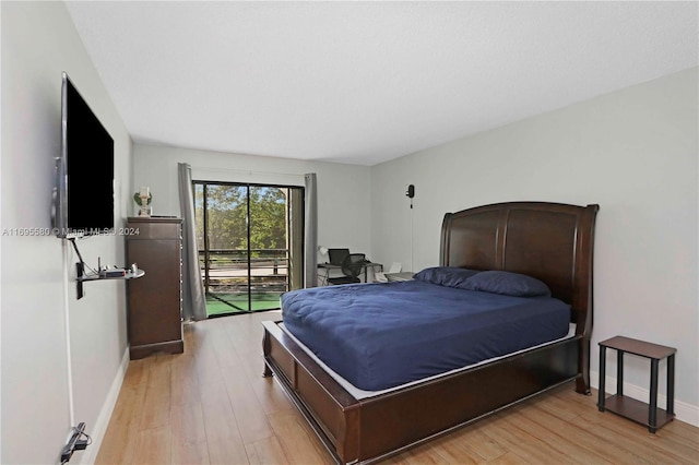 bedroom with access to exterior and light hardwood / wood-style flooring