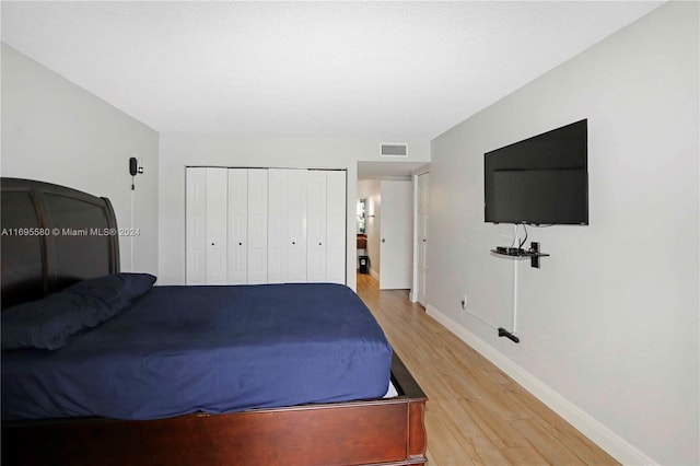 bedroom with wood-type flooring and a closet