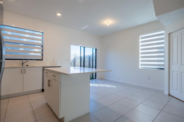 kitchen featuring white cabinetry, a center island, and light tile patterned flooring