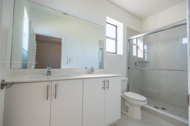 bathroom with tile patterned floors, vanity, toilet, and a shower with shower door