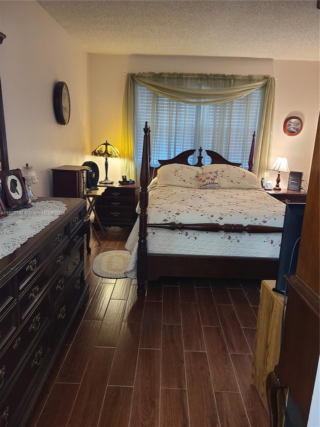 bedroom with a textured ceiling and dark wood-type flooring