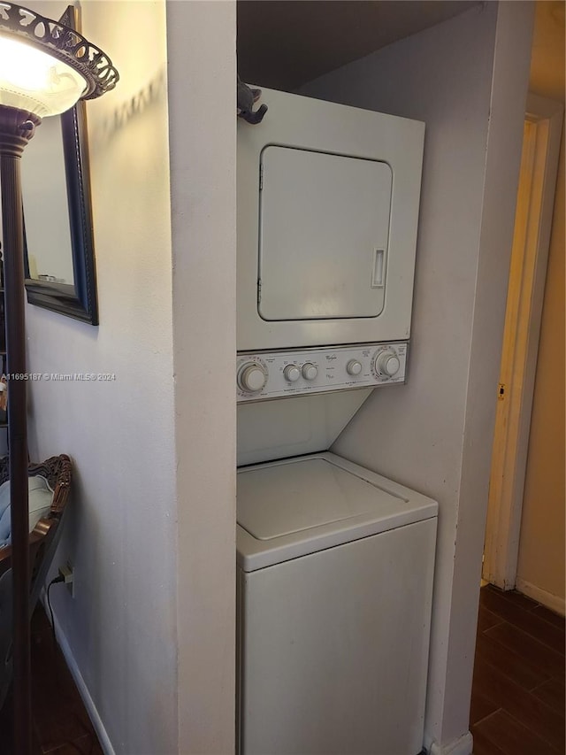 laundry area featuring dark hardwood / wood-style floors and stacked washer and clothes dryer