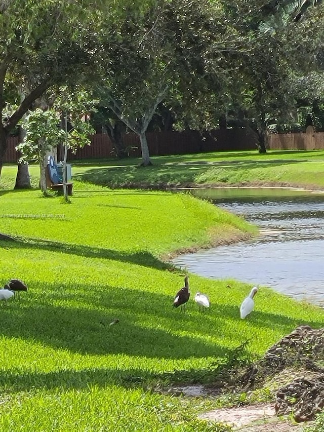 view of property's community with a yard and a water view