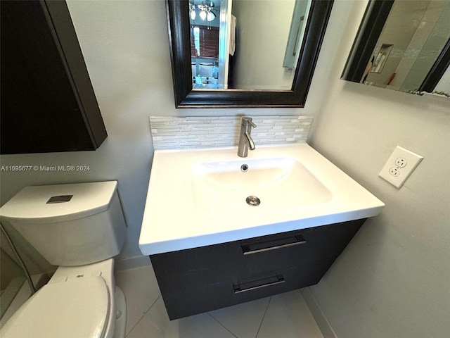 bathroom with tile patterned floors, vanity, tasteful backsplash, and toilet