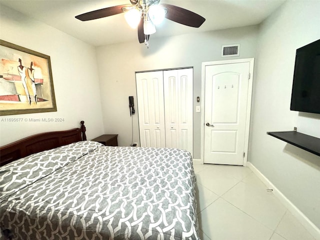 bedroom with ceiling fan, a closet, and light tile patterned floors