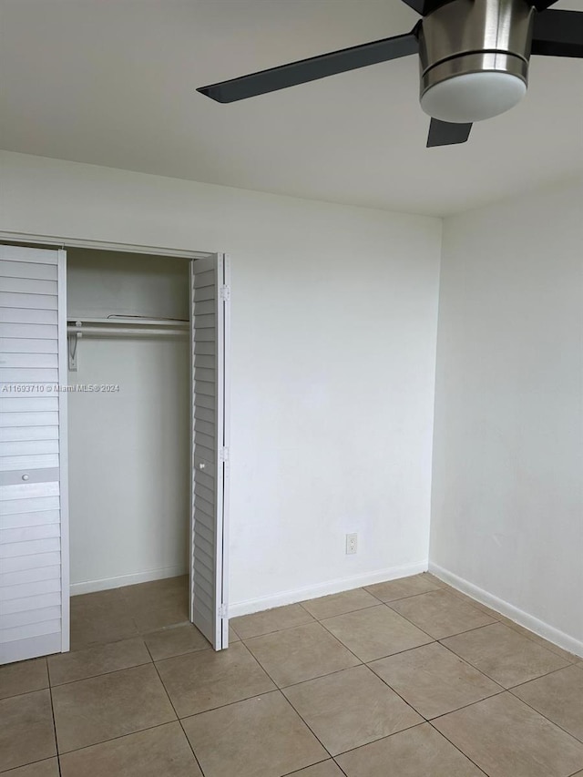 interior space featuring ceiling fan, light tile patterned floors, and a closet