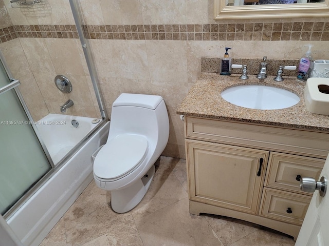 full bathroom featuring combined bath / shower with glass door, backsplash, vanity, tile walls, and toilet