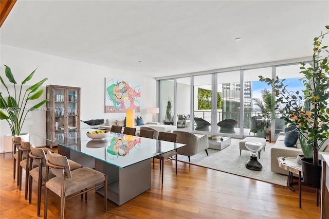 dining room featuring floor to ceiling windows and hardwood / wood-style floors