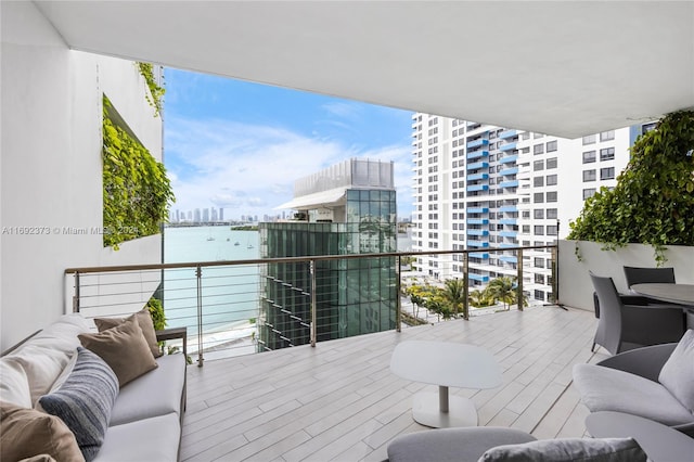 balcony featuring a water view and an outdoor hangout area