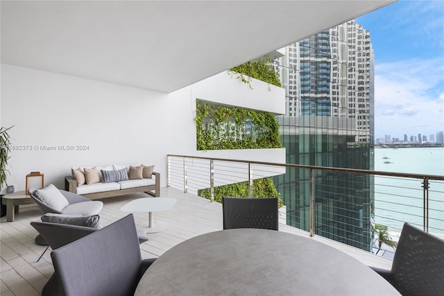 balcony with a water view and an outdoor hangout area