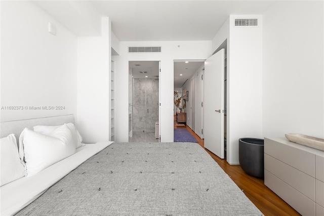 bedroom featuring hardwood / wood-style flooring and ensuite bath