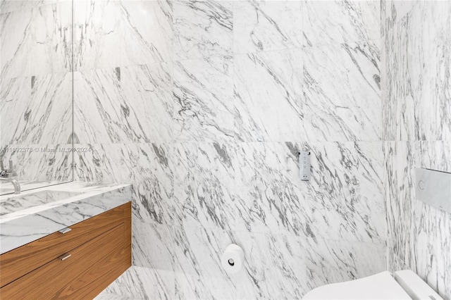 bathroom with vanity and tile walls