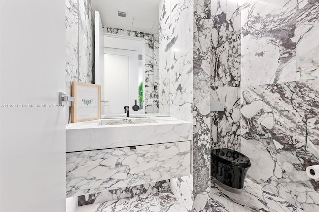 bathroom featuring vanity and tile walls