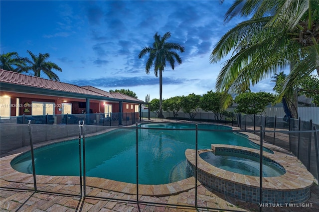 pool at dusk with an in ground hot tub