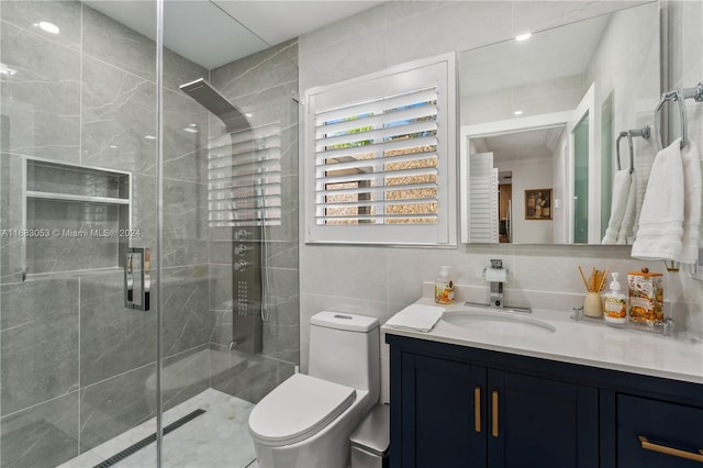 bathroom featuring vanity, a shower with shower door, tile walls, and toilet