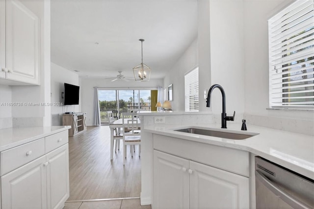 kitchen with dishwasher, sink, light wood-type flooring, decorative light fixtures, and white cabinetry