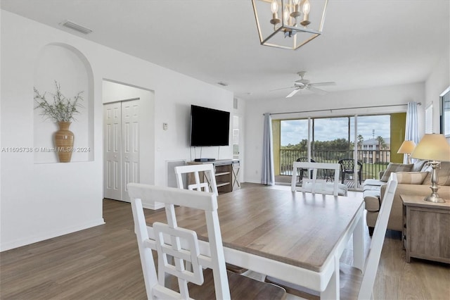 dining space featuring ceiling fan with notable chandelier and dark hardwood / wood-style floors