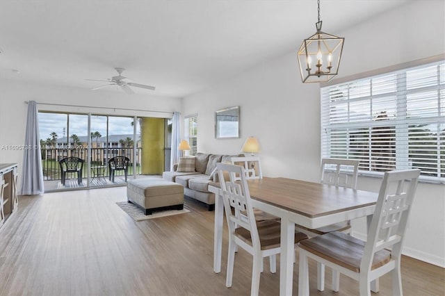 dining area with ceiling fan with notable chandelier and light wood-type flooring