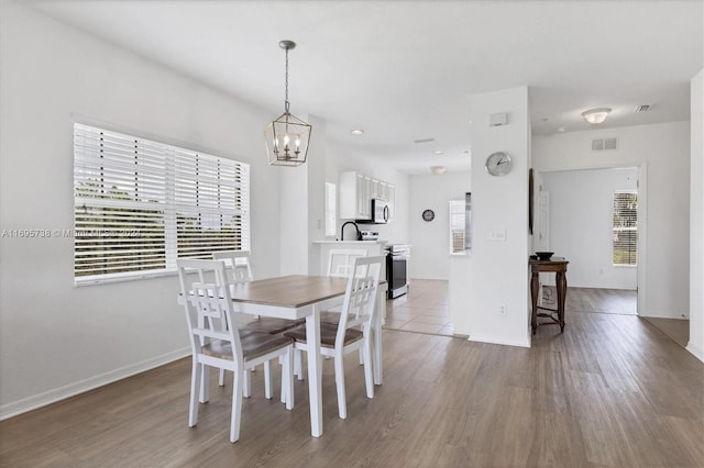 dining space with light wood-type flooring and a chandelier