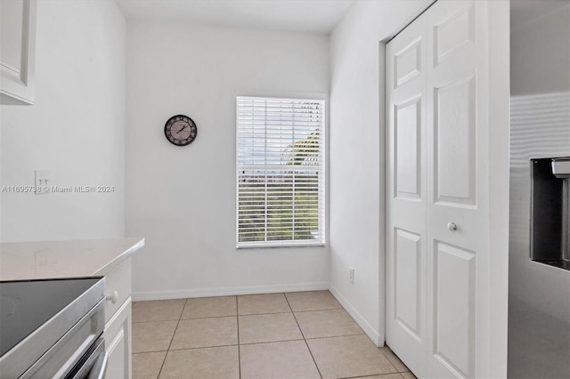 kitchen with stainless steel range and light tile patterned floors