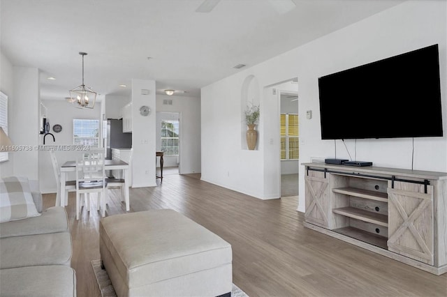 living room featuring hardwood / wood-style floors and ceiling fan with notable chandelier