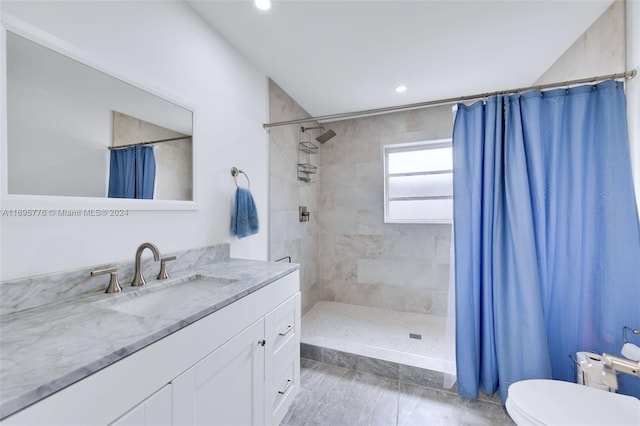 bathroom with toilet, vanity, and walk in shower