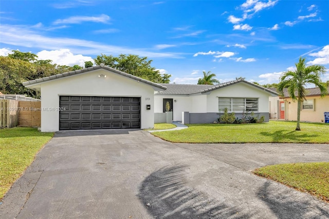 single story home featuring a garage and a front lawn