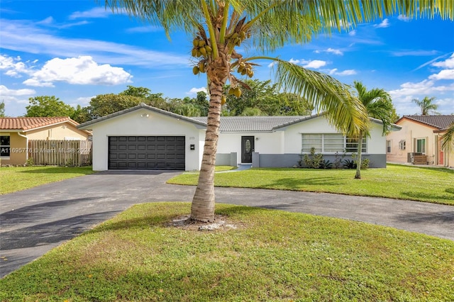 ranch-style home featuring a garage and a front lawn