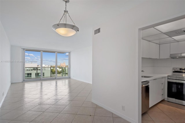 kitchen featuring stainless steel appliances, white cabinets, decorative light fixtures, decorative backsplash, and light tile patterned floors