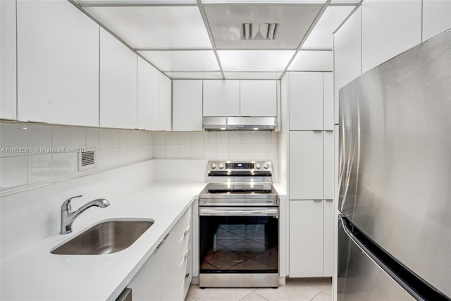 kitchen featuring sink, white cabinets, light tile patterned flooring, and appliances with stainless steel finishes